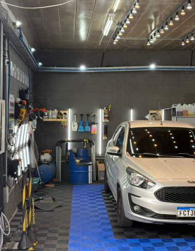 Estúdio da JC Estética Automotiva com carro prata em lavagem completa sob iluminação profissional